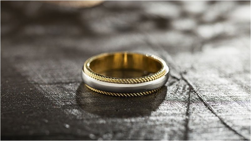 Серебряное и золотое кольцо на черном фоне