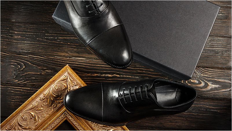 Вид сверху на черные оксфордские мужские туфли с золотым бидермейером