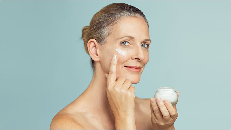Зрелая женщина, применяя крем для кожи на лице